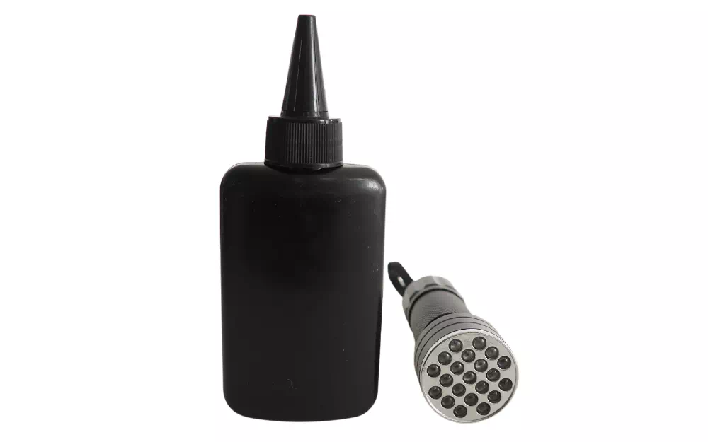 Flacon noir opaque avec bec verseur et lampe UV portative